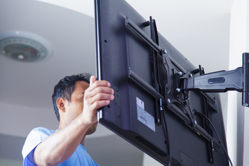 Installer fitting a TV onto a moving wall mount
